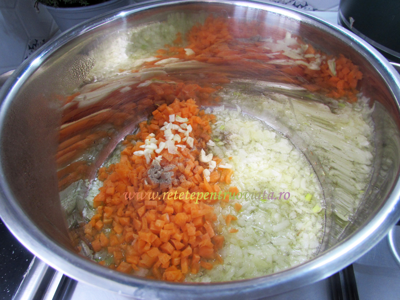 Adaugam morcovul si cateii de usturoi tocati marunt impreuna cu o jumatate de lingurita de piper. Amestecam si continuam calirea timp de aproximativ doua minute.