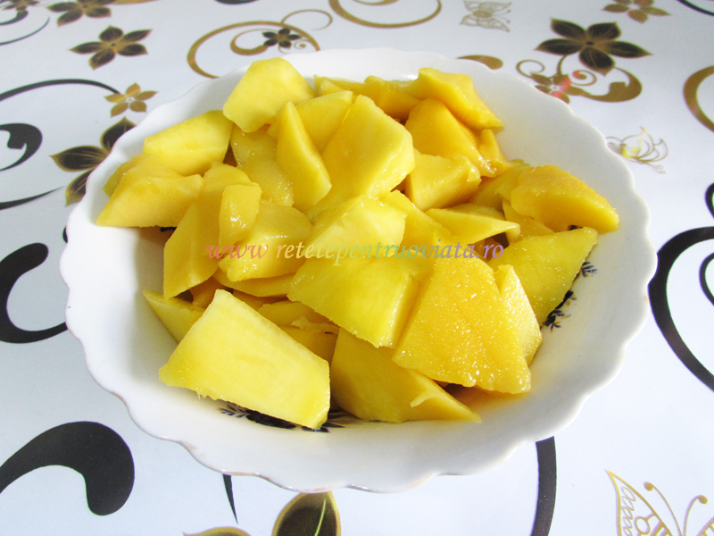 Taiem fructul de mango pe jumatate, de o parte si de cealalta a samburelui, si tocam pulpa